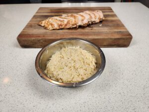 grilled chicken behind a bowl of risotto