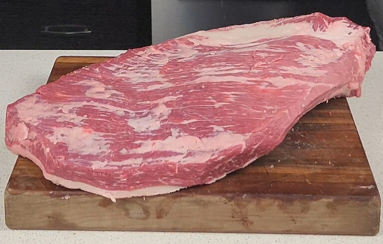 Brisket, trimmed on cutting board. Uncooked, unseasoned